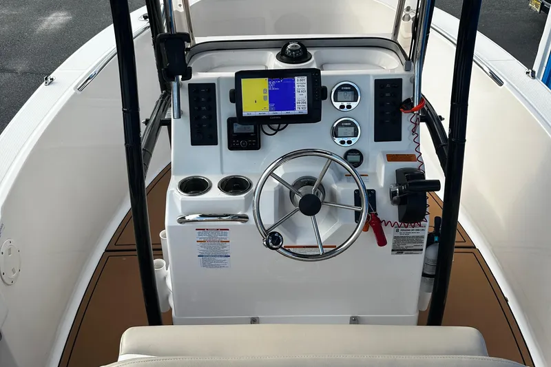 Slide: The Image of 2018 Robalo R180 Center Console boat dashboard with steering wheel and navigation equipment. - 13