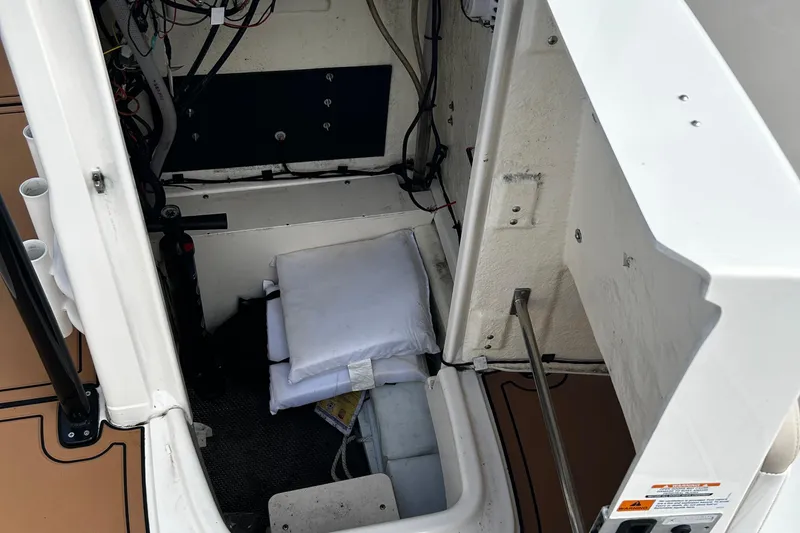 Slide: The Image of 2018 Robalo R180 Center Console storage compartment with wiring and safety equipment. - 22