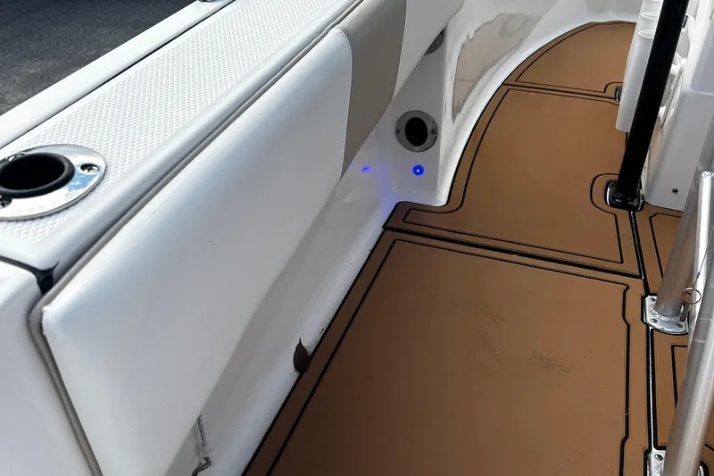 Slide: The Image of 2018 Robalo R180 Center Console interior with tan flooring and white seating. - 23