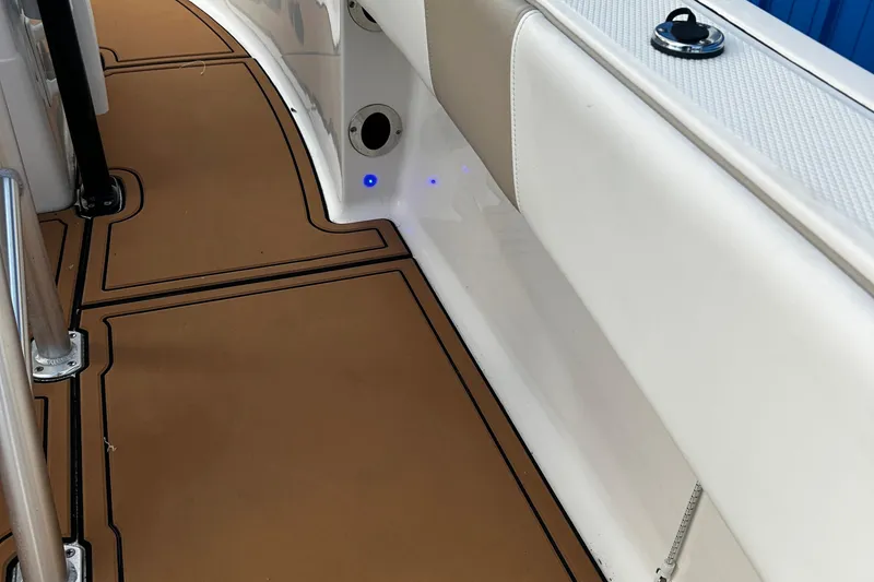 Slide: The Image of 2018 Robalo R180 Center Console boat interior with tan flooring and white seating. - 24
