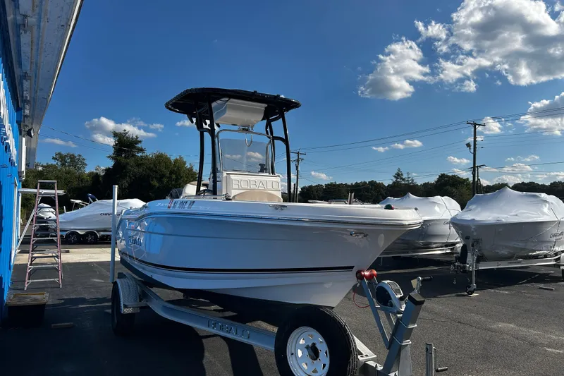 Slide: The Image of 2018 Robalo R180 Center Console boat on trailer under clear blue sky. - 4