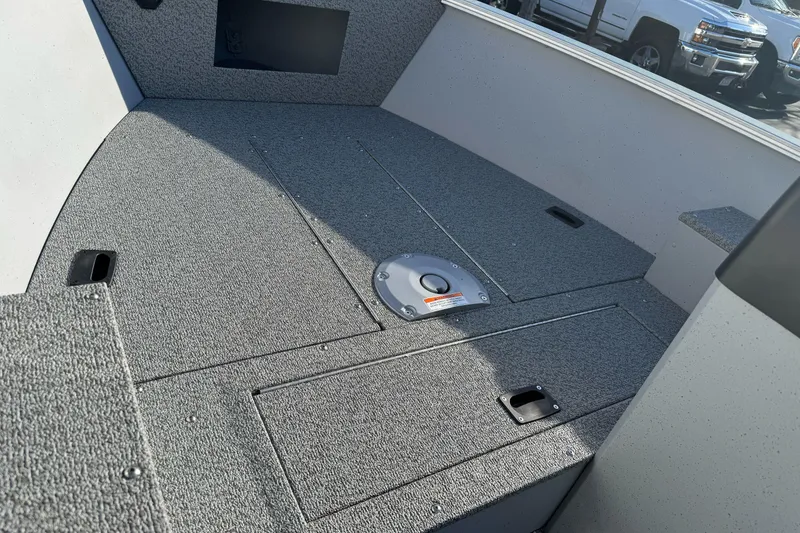 Slide: The Image of 2026 Lund 1400 Fury SS boat interior with carpeted deck and storage compartments. - 11
