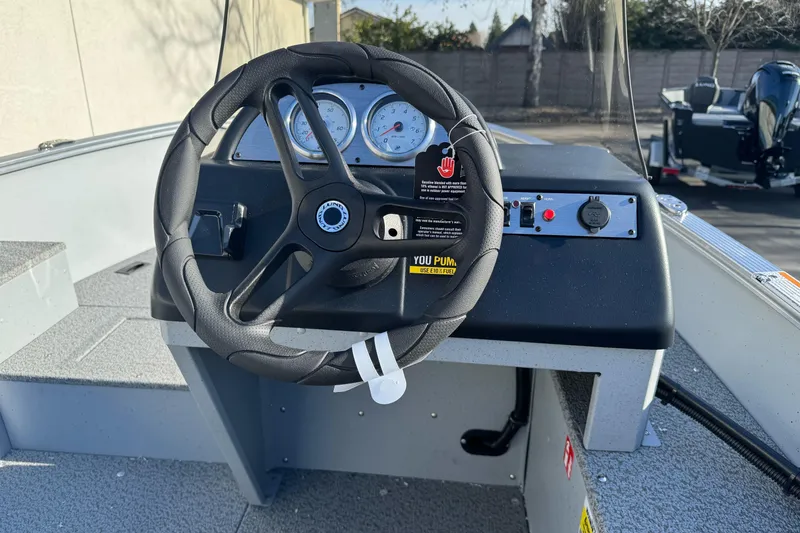 Slide: The Image of 2026 Lund 1400 Fury SS boat dashboard with steering wheel and gauges. - 12