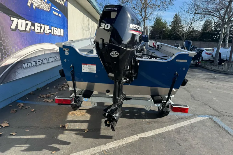 Slide: The Image of 2026 Lund 1400 Fury SS boat with Mercury 30 outboard motor in parking lot. - 5