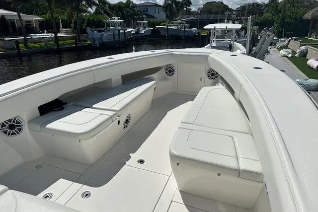 Slide: The Image of 2024 SeaVee 340Z boat interior with white seating and speakers, docked near waterfront homes. - 14