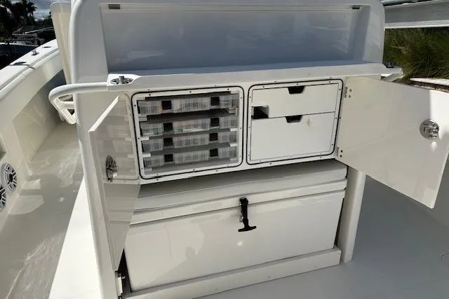 Slide: The Image of 2024 SeaVee 340Z boat storage compartments with open doors and organized tackle boxes. - 21
