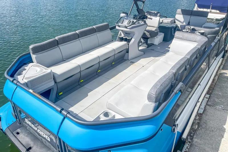 Slide: The Image of 2023 Sea-Doo Switch Cruise 21 pontoon boat with spacious seating on calm water. - 12