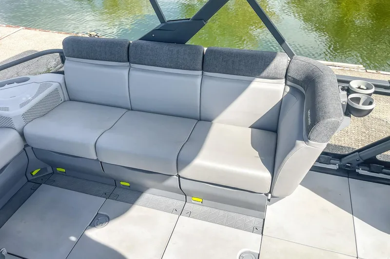Slide: The Image of 2023 Sea-Doo Switch Cruise 21 interior seating with gray upholstery by the water. - 18