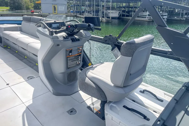 Slide: The Image of 2023 Sea-Doo Switch Cruise 21 interior with helm and seating, docked by the water. - 5