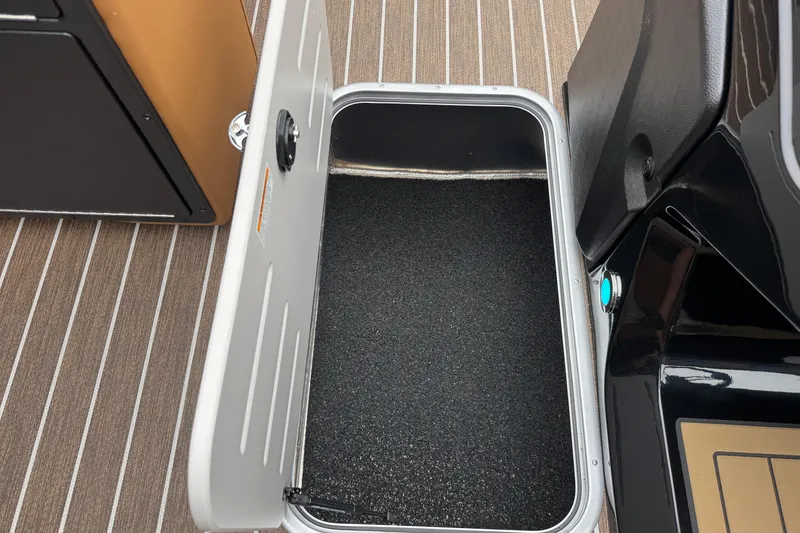 Slide: The Image of Open storage compartment on 2026 Premier 230 Solaris RL boat with striped flooring. - 13