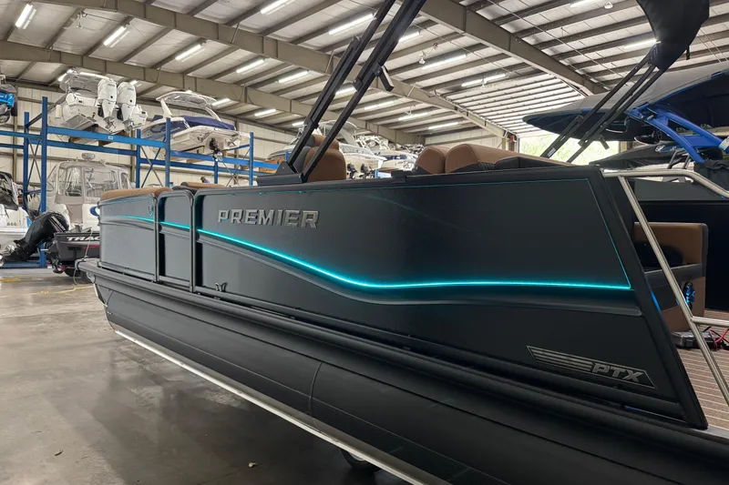 Slide: The Image of 2026 Premier 230 Solaris RL pontoon boat in a showroom with sleek design and blue lighting. - 25