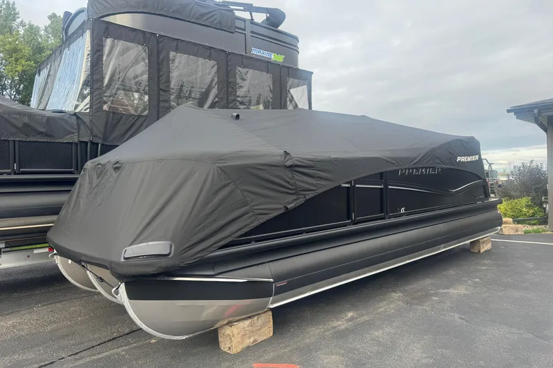 Slide: The Image of 2026 Premier 230 Solaris RL pontoon boat covered, parked on a driveway. - 26