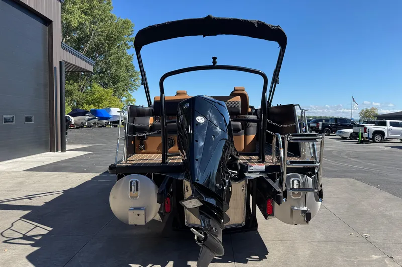 Slide: The Image of 2026 Premier 230 Solaris RL pontoon boat with outboard motor, docked outdoors. - 5