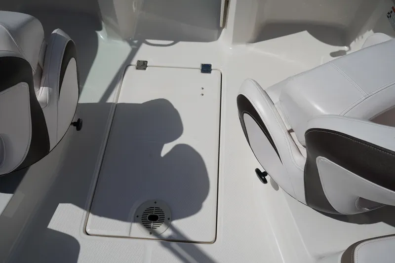 Slide: The Image of 2020 Chaparral 23 SSi OB boat interior with white seating and storage compartment. - 14