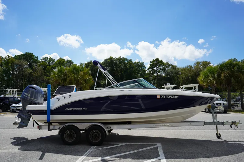 Slide: The Image of 2020 Chaparral 23 SSi OB boat on trailer, parked outdoors under blue sky. - 2