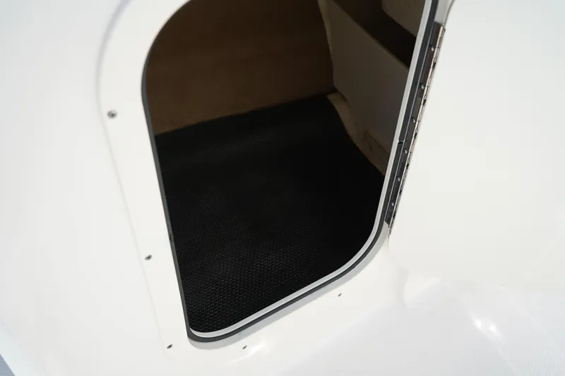 Slide: The Image of 2020 Chaparral 23 SSi OB boat storage compartment with black interior mat. - 22