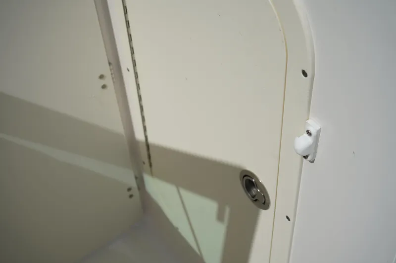 Slide: The Image of 2020 Chaparral 23 SSi OB boat interior detail with latch and hinge. - 28