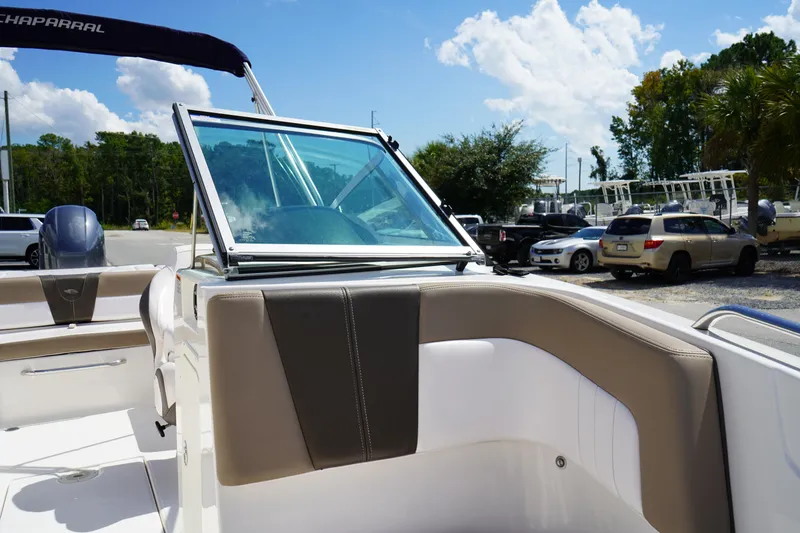 Slide: The Image of 2020 Chaparral 23 SSi OB boat interior with windshield and seating, parked outdoors. - 32