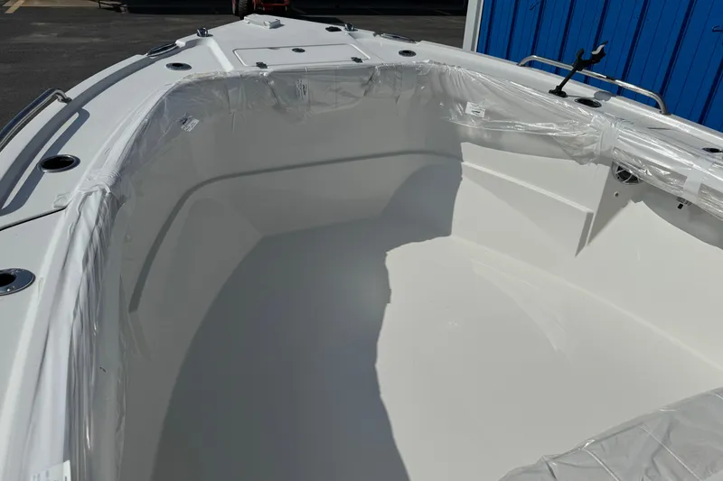 Slide: The Image of 2025 Parker 230 Coastal Elite boat interior, wrapped in protective plastic, dockside view. - 10