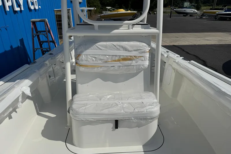 Slide: The Image of 2025 Parker 230 Coastal Elite boat interior with white seating and protective covers. - 11