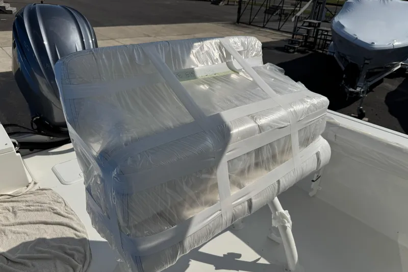 Slide: The Image of 2025 Parker 230 Coastal Elite boat seat wrapped in protective plastic on deck. - 13