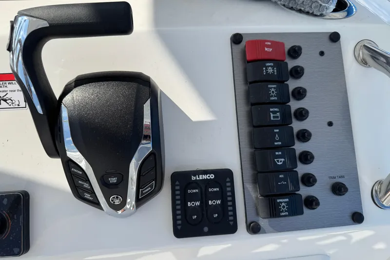 Slide: The Image of Control panel of 2025 Parker 230 Coastal Elite boat with throttle and switches. - 21