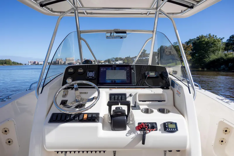 Slide: The Image of 2007 Pursuit C 300 Center Console boat dashboard with steering wheel and navigation equipment. - 19