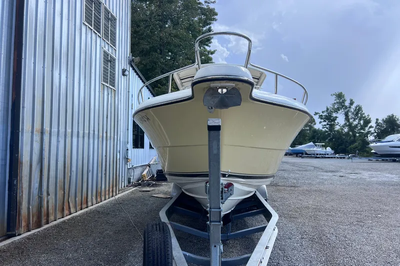 Slide: The Image of 2007 Pursuit C 300 Center Console boat with dual engines on a calm lake. - 2