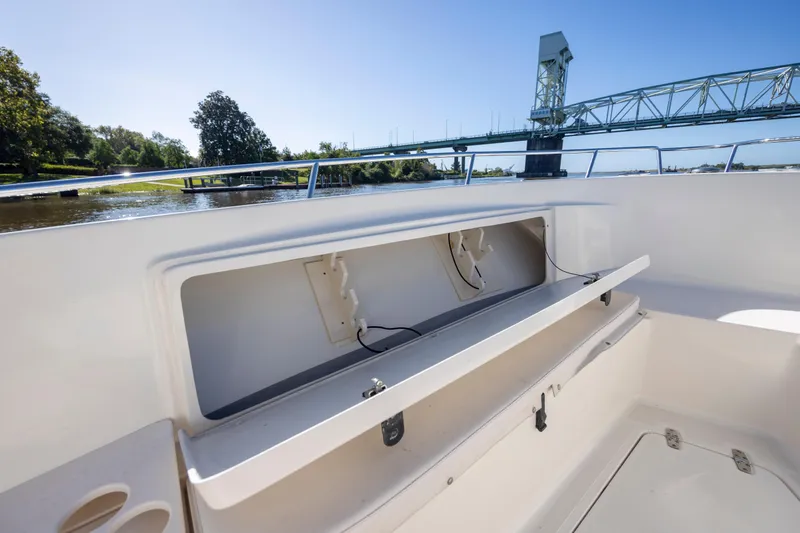 Slide: The Image of 2007 Pursuit C 300 Center Console boat with open storage, near a bridge on a sunny day. - 24