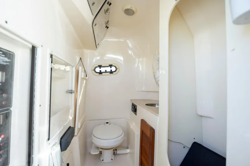 Slide: The Image of 2007 Pursuit C 300 Center Console boat interior with toilet and sink. - 29
