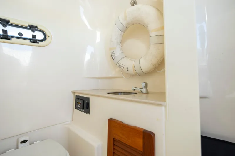 Slide: The Image of 2007 Pursuit C 300 Center Console interior with sink, life preserver, and window. - 30