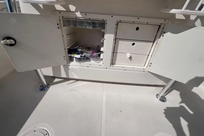 Slide: The Image of 2007 Pursuit C 300 Center Console boat on calm water, surrounded by lush greenery. - 9