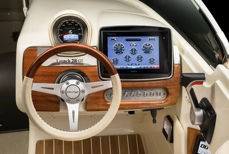 Slide: The Image of Manufacturer Provided Image: 2025 Chris-Craft Launch 28 GT dashboard with wood accents and modern navigation display. - 11