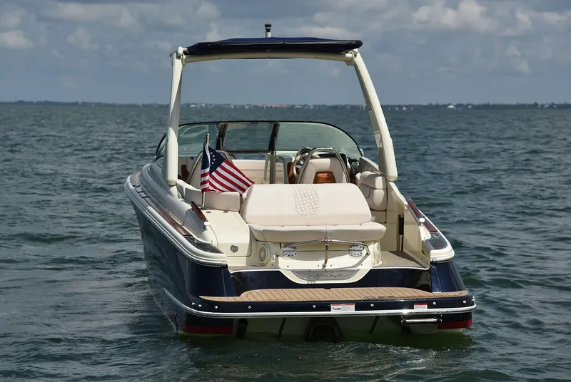 Slide: The Image of Manufacturer Provided Image: 2025 Chris-Craft Launch 28 GT boat on water, rear view with American flag. - 4