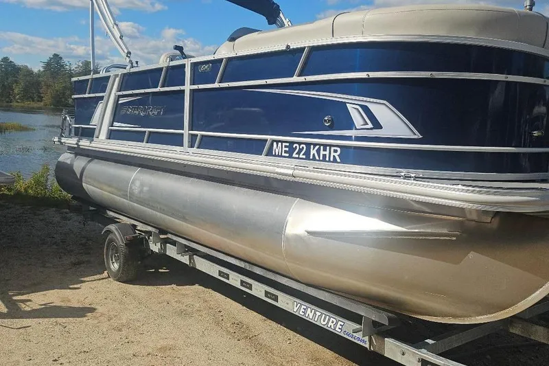 Slide: The Image of 2019 Starcraft EX 20 C pontoon boat on trailer by a lake. - 10