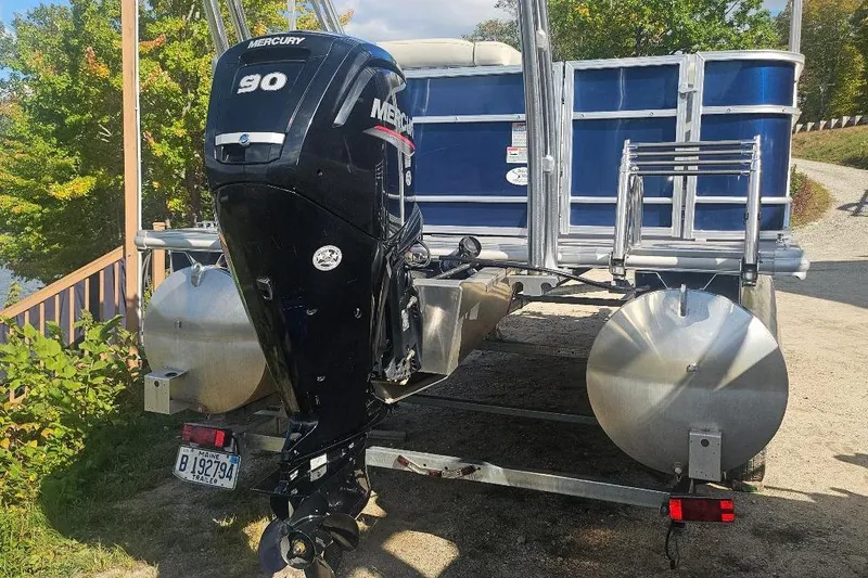 Slide: The Image of 2019 Starcraft EX 20 C pontoon boat with Mercury 90 outboard motor on trailer. - 2