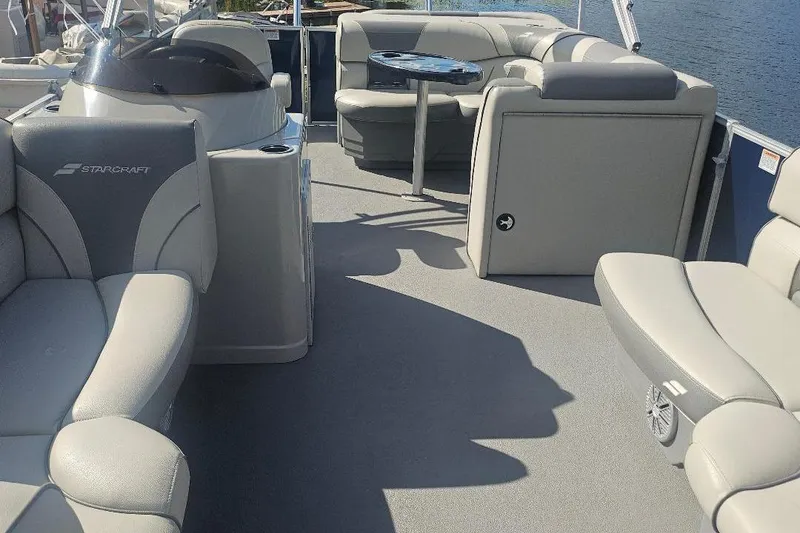 Slide: The Image of 2019 Starcraft EX 20 C pontoon boat interior with plush seating and table. - 7