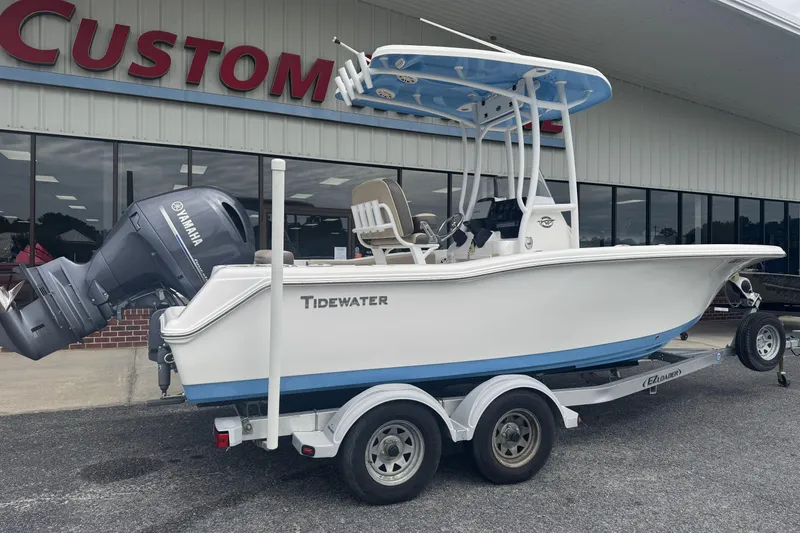 Slide: The Image of 2020 Tidewater 210 CC Adventure boat on trailer, parked outside a custom shop. - 2