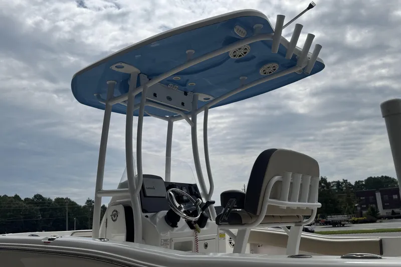 Slide: The Image of 2020 Tidewater 210 CC Adventure boat with T-top and helm, under cloudy sky. - 20