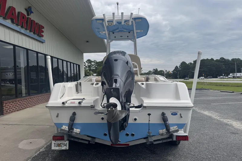 Slide: The Image of 2020 Tidewater 210 CC Adventure boat with outboard motor, parked outside a marine store. - 4