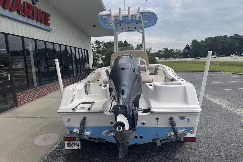 Slide: The Image of 2020 Tidewater 210 CC Adventure boat with outboard motor, parked outside a marine store. - 5