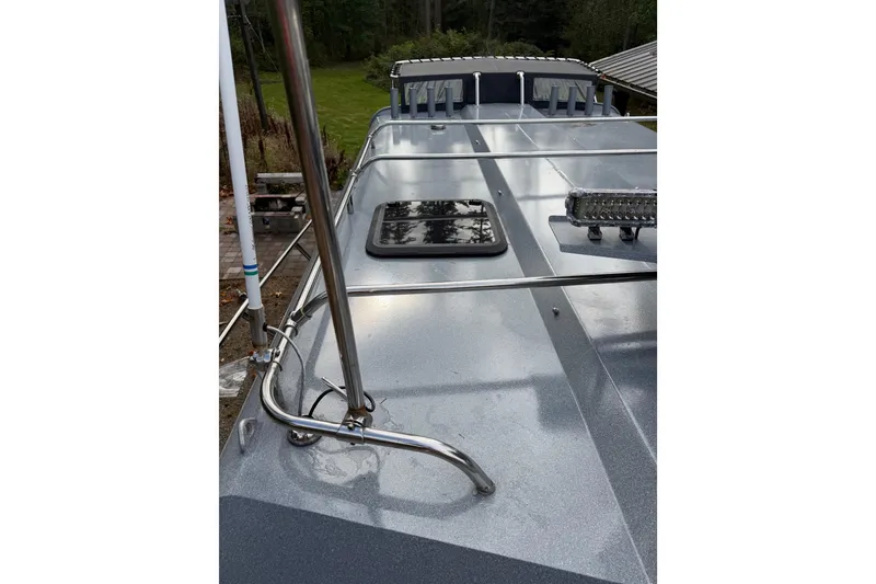 Slide: The Image of 2017 KingFisher 2825 Offshore boat deck with railing and hatch, surrounded by greenery. - 36