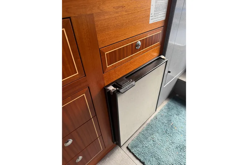 Slide: The Image of Wooden cabinetry and mini fridge inside 2017 KingFisher 2825 Offshore boat interior. - 68