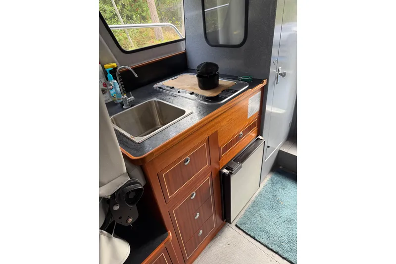 Slide: The Image of 2017 KingFisher 2825 Offshore boat interior with kitchenette, sink, and storage cabinets. - 69