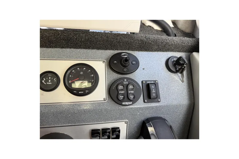 Slide: The Image of Dashboard controls of a 2017 KingFisher 2825 Offshore boat, featuring gauges and switches. - 76