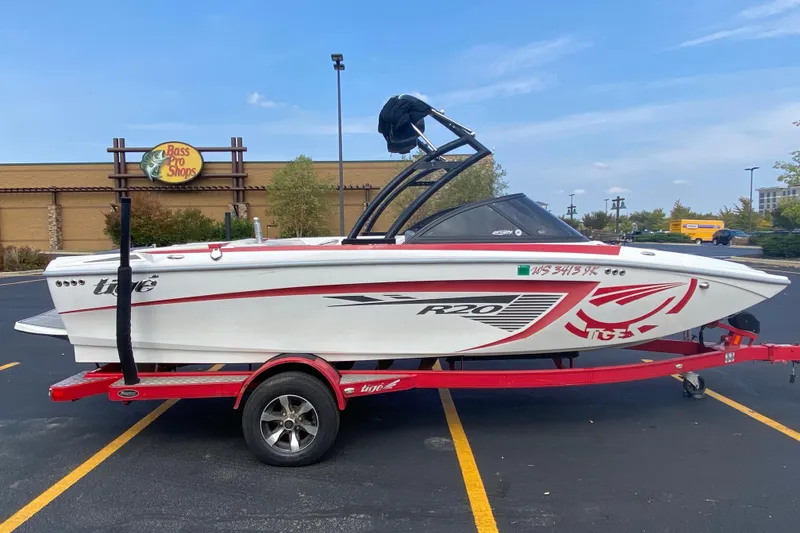The Image of 2014 Tigé R20 boat on red trailer in parking lot near Bass Pro Shops. - 0