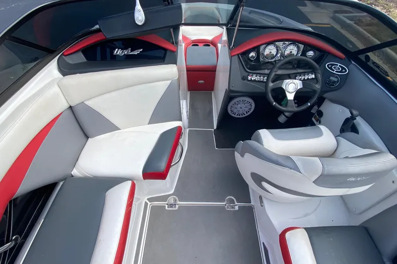 Slide: The Image of 2014 Tigé R20 boat interior with red, gray, and white seating and modern dashboard. - 5