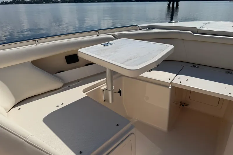 Slide: The Image of 2017 Grady-White Freedom 335 boat interior with seating and table on calm water. - 16