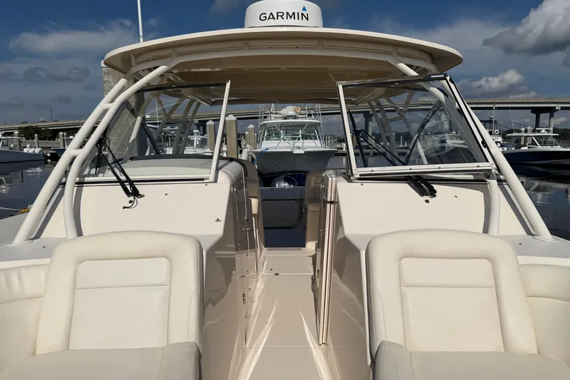 Slide: The Image of 2017 Grady-White Freedom 335 boat docked, featuring spacious seating and Garmin equipment. - 21