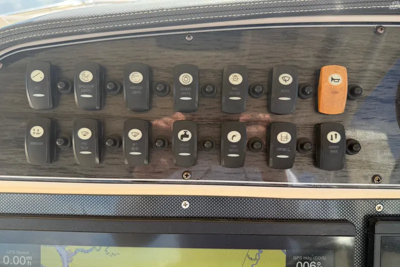 Slide: The Image of Dashboard controls of a 2017 Grady-White Freedom 335 boat, featuring various switches. - 30